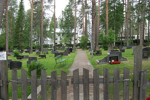 Näkymä hautausmaalle päin puiselta portilta kuvattuna.