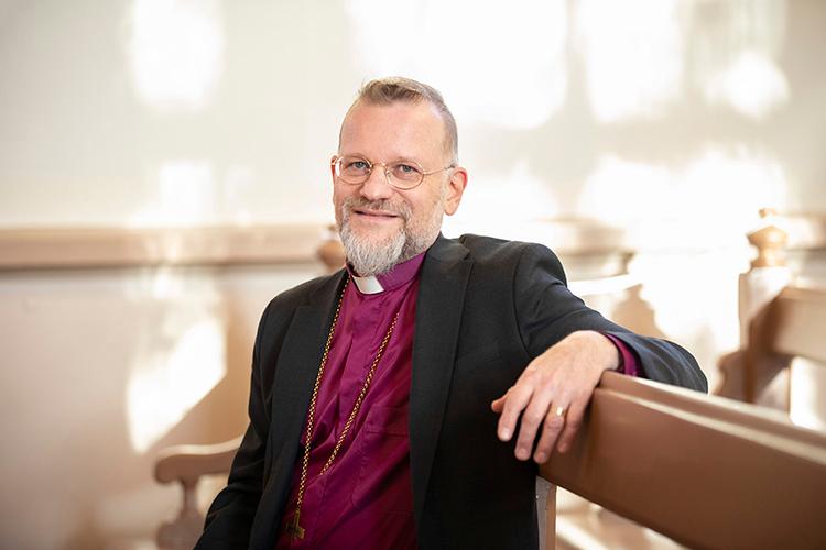 Piispa Jari Jolkkonen istuu Tuomiokirkon penkissä.