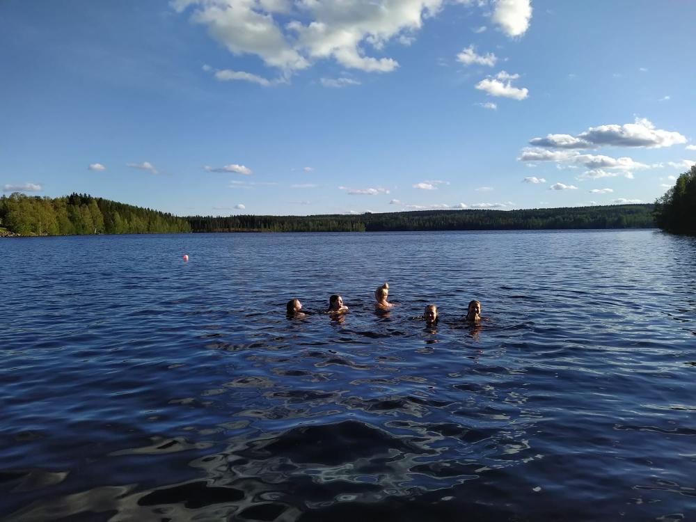 5 ihmistä uimassa järvessä.