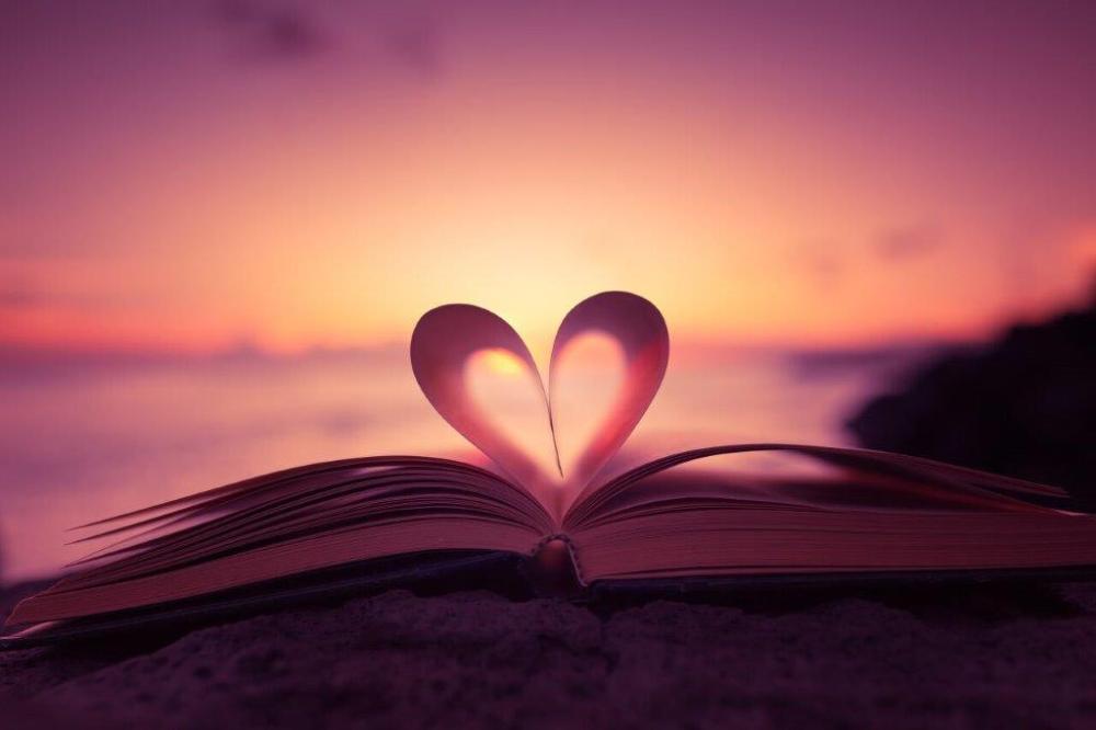 Avoin kirja, jonka sivuja on käännetty sydämen muotoon.