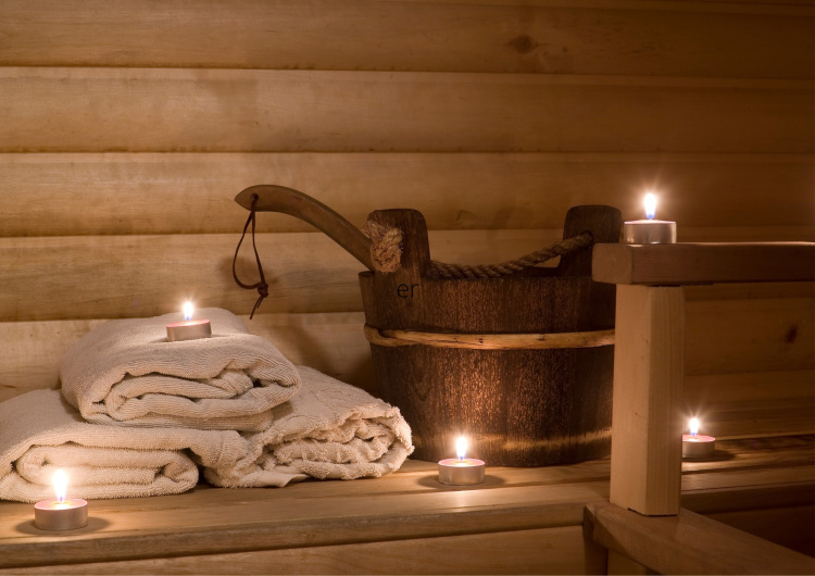 Afterwork + sauna työikäisille naisille Saunan lauteilla pyyhkeitä, vesikiulu ja kauha sekä kynttilöitä
