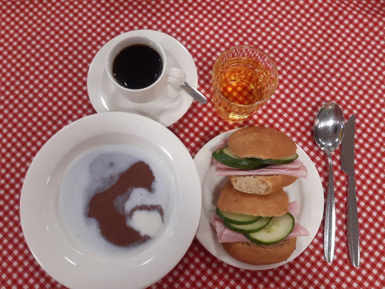 Arkinen aamupala Puuroa, täytettyjä sämpylöitä lautasella, kahvia ja mehua.