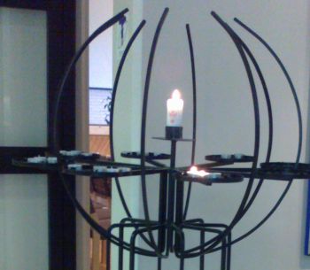 Musta lähetyskynttelikkö, jossa keskellä kynttilä, jossa linkki