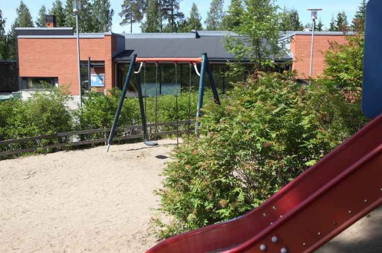 Pihaseurat Petosen seurakuntatalo, pihalla kiikku, pensaita ja liukumäki.