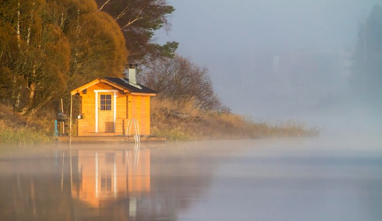 Sauna rakennus rannalla, järvellä usvaa.