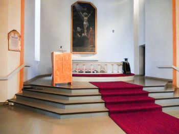 Syvänniemen kirkon alttari, alttaritaulu, puhujapönttö ja punainen matto rappisilla.