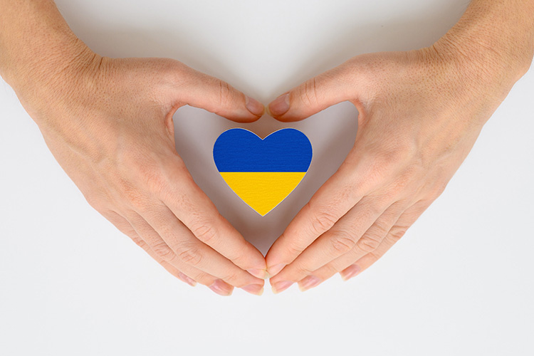 KoillisSet Viihdekuoron konsertti Käsien välissä Ukrainan lipun väreissä oleva sydänkuvio.