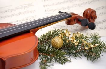 viulu nuottien päällä ja vieressä havusta tehty koriste, jossa joulupallo