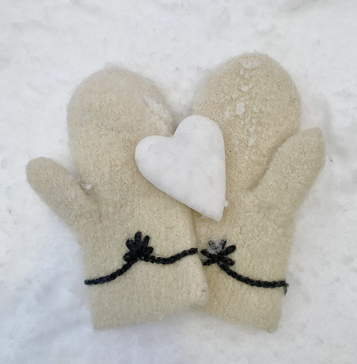 Ystävänpäiväkerho Kahden lapasen päällä lumisydän.