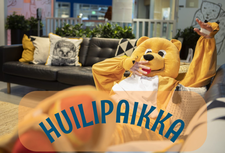 Kuvassa nalleasuinen henkilö pötköttelee sohvalla.