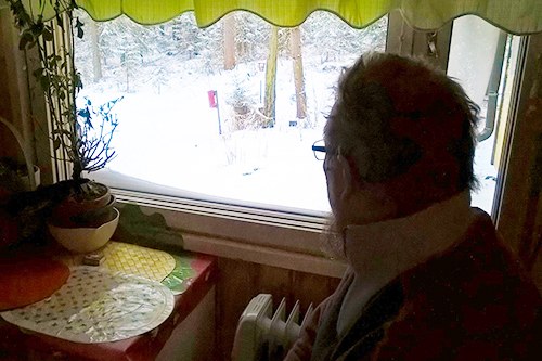 Yksinäinen vanhus istuu ikkunan ääressä