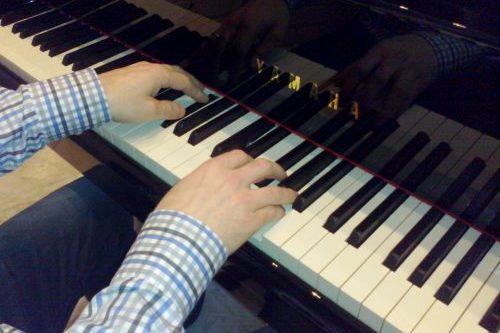 Kädet pianon koskettimilla.