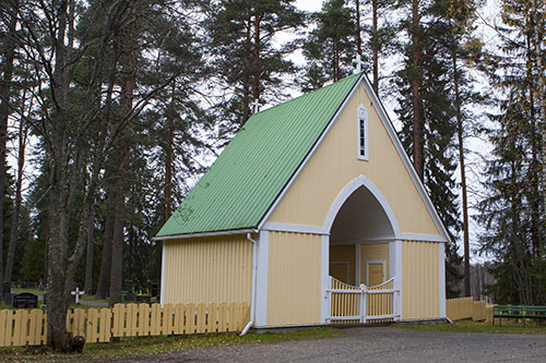 Hautausmaan porttina oleva holvikaarellinen puurakennus.