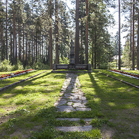 Yhteismuistomerkki laattakivetyn käytävän päässä.