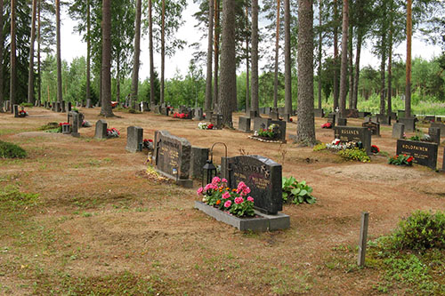 Hiekkahautoja ja muistomerkkejä kesäisellä hautausmaalla.