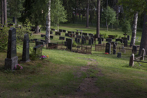 Vanhoja muistomerkkejä ja rautaisia aitoja hautojen ympärillä.