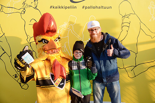 Ruusteri-maskotti poseeraa Aatu Pantsun ja hänen kummisetänsä Tero Vainikaisen kanssa.