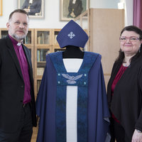 kuvassa piispa Jari Jolkkonen, Helena Vaari ja uusi piispankaapu