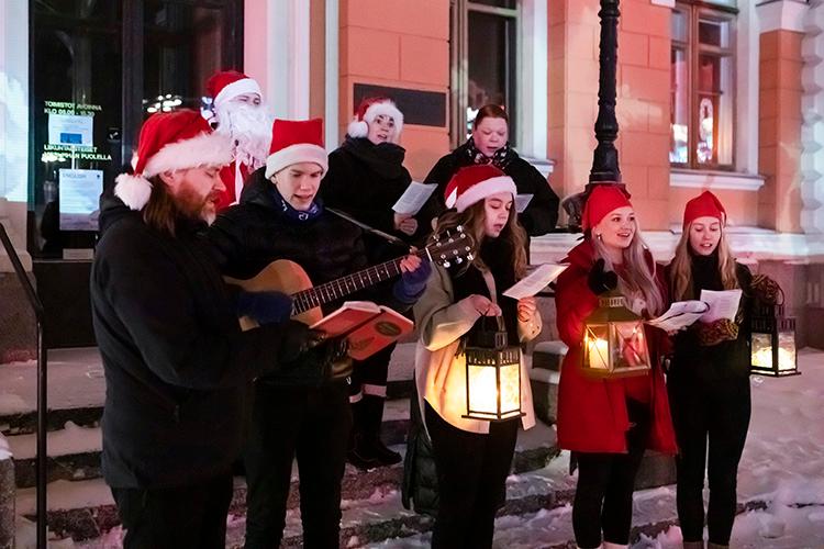Soivan joulukortin laulajat kaupungintalon edessä lyhtyineen laulamassa.