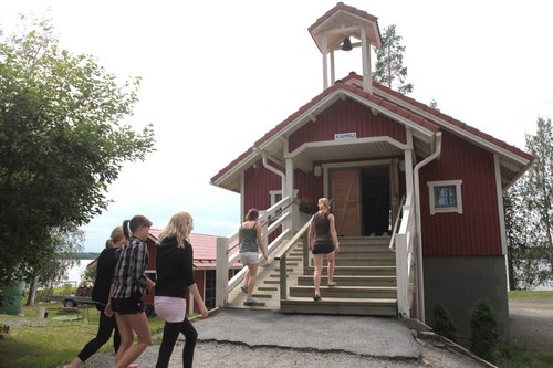 Leiriläisiä astumassa sisälle kappeliin leirikeskus Hirvijärvellä.